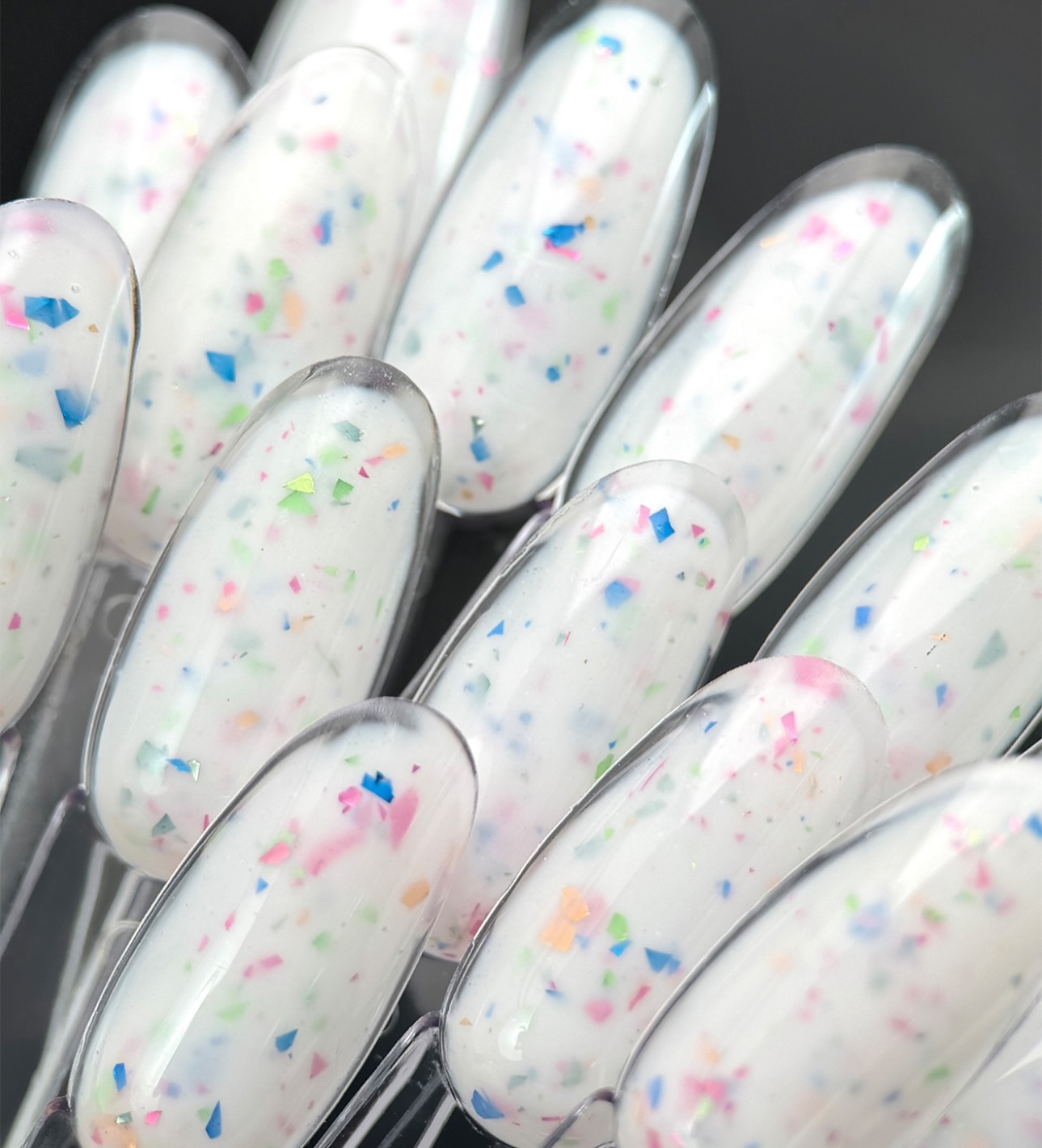 Proeftips met melkwitte gellak en gekleurde confetti-flakes
